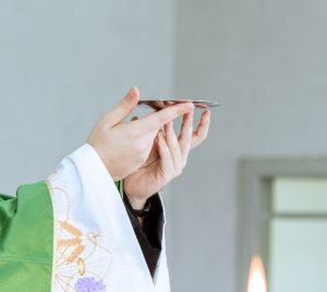 a person in a priest's robe holding a cell phone