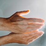 persons hand with white nail polish